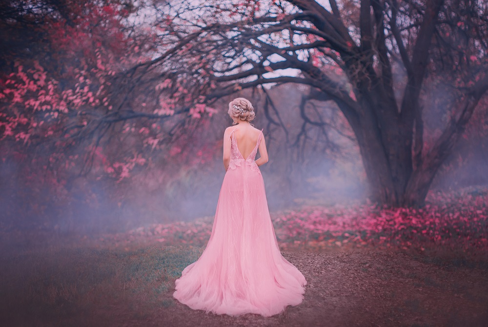 Różowa suknia ślubna. Panna młoda w różowej sukni ślubnej w lesie.
