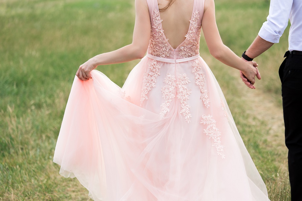 Różowa suknia ślubna. Panna młoda w różowej sukni ślubnej z rozciętym tyłem.