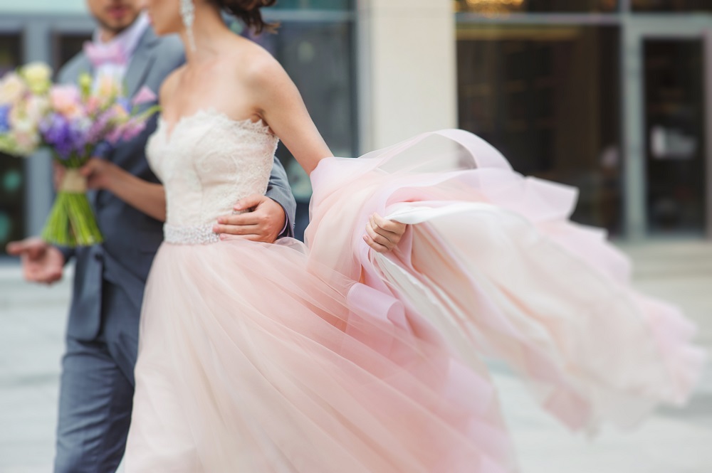Różowa suknia ślubna. Panna młoda w zwiewnej, różowej sukni ślubnej w mieście.
