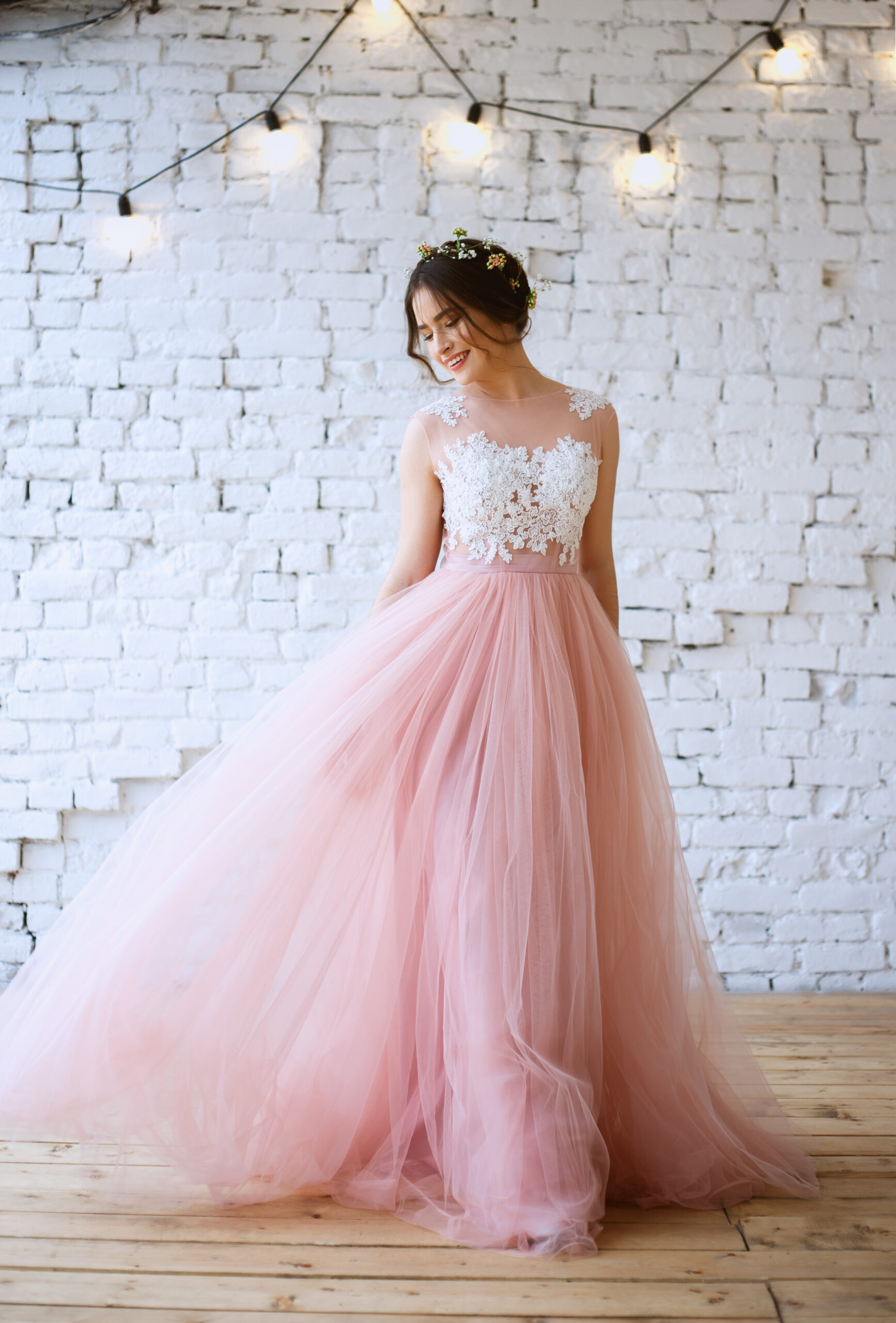 Różowa suknia ślubna. Uśmiechnięta panna młoda w różowej sukni ślubnej.