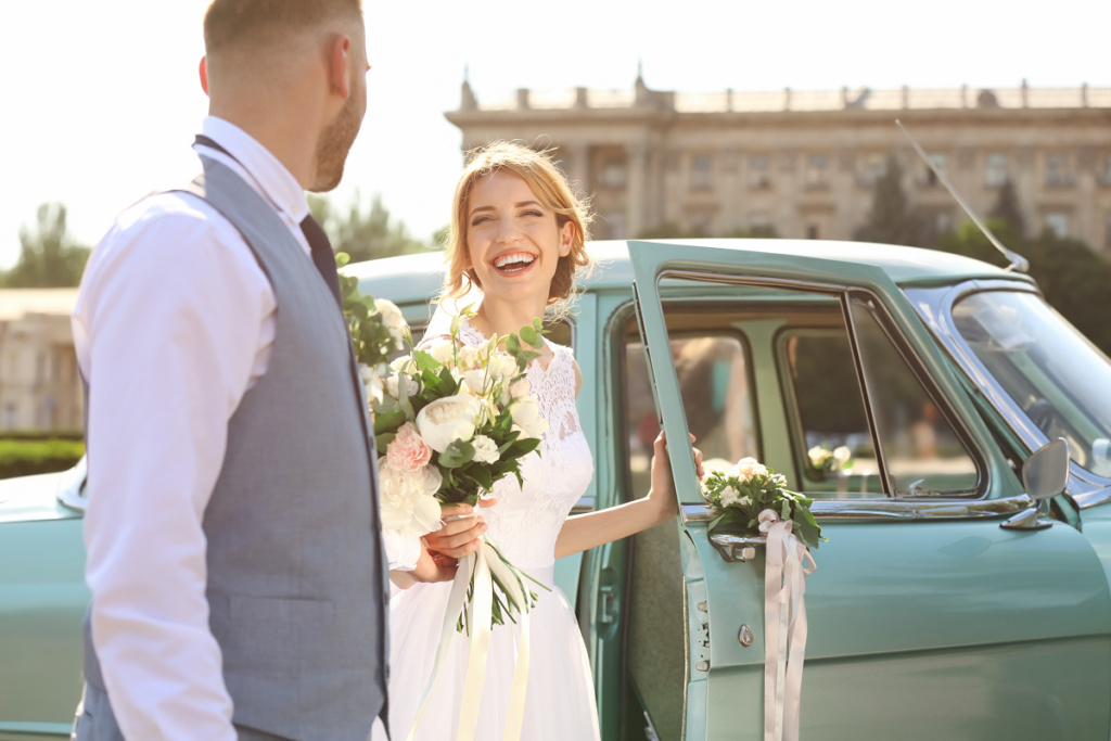 Brama weselna - uśmiechnięta para młoda wsiadająca do samochodu