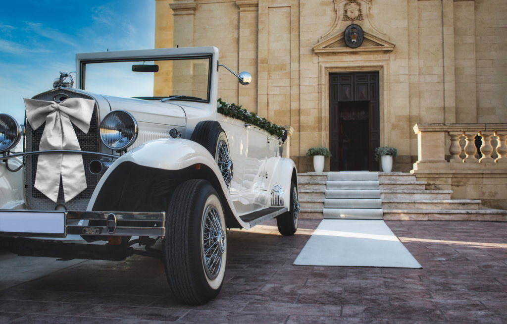 Brama weselna - auto do ślubu stojące przed kościołem
