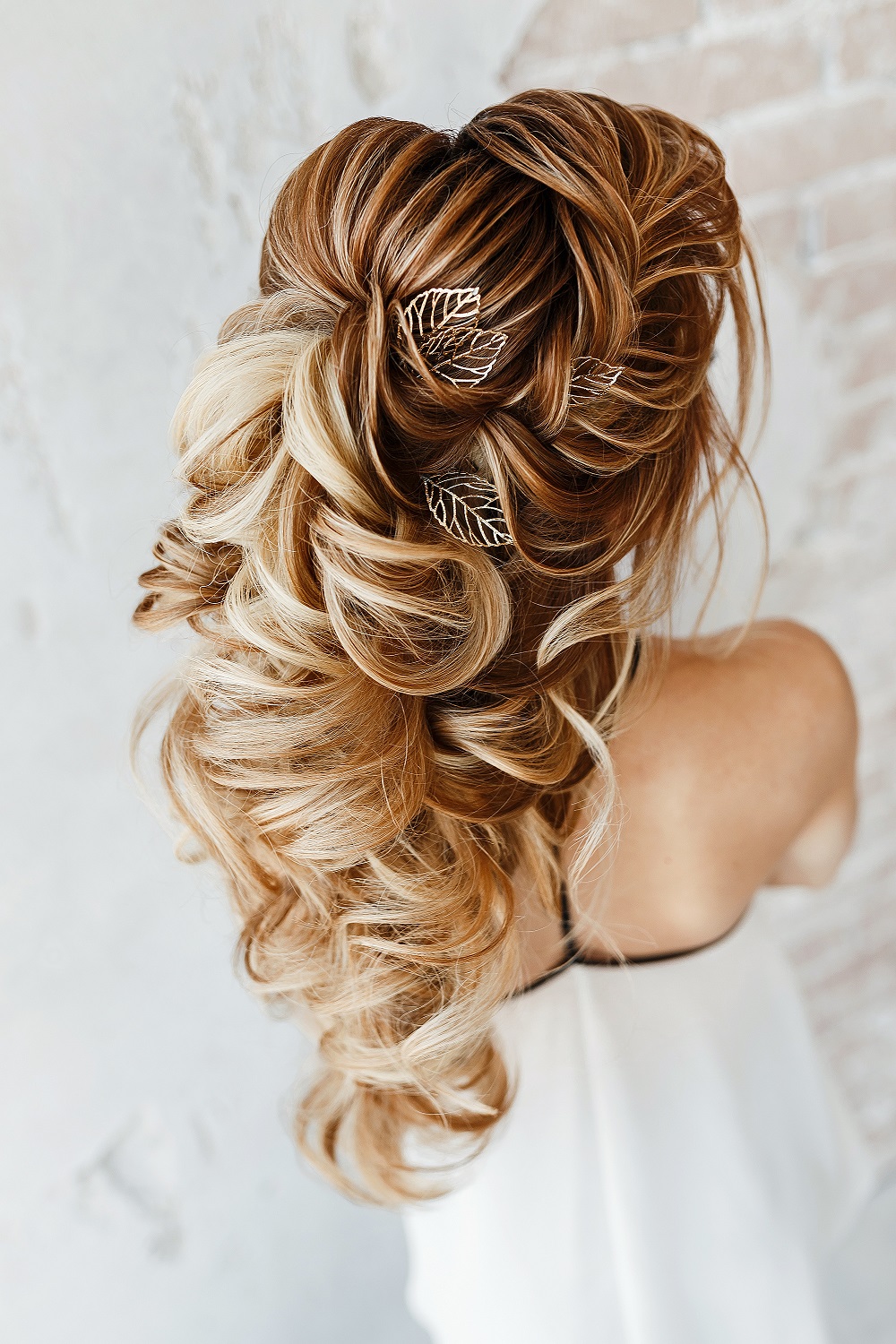 Piękne kaskadowe upięcie na długich blond włosach jako przykład fryzury na wesele.