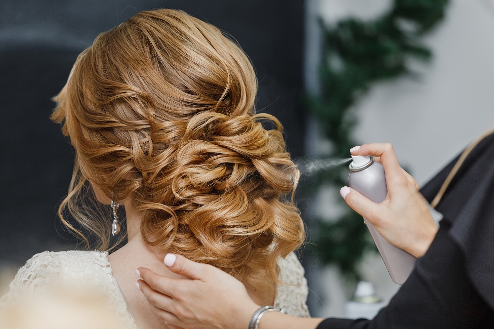 Duży kok zrobiony na długich włosach jako przykład fryzury na wesele.