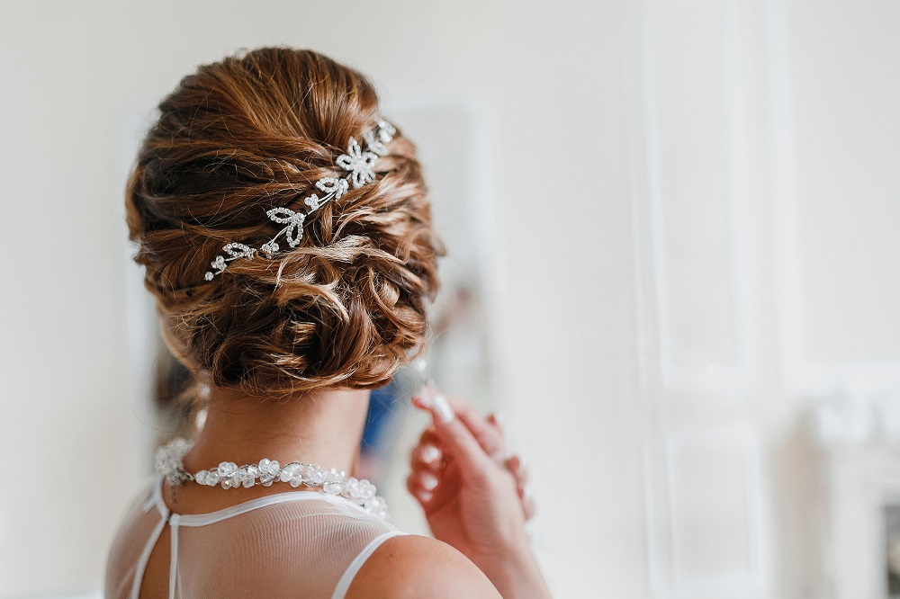 Śliczne upięcie z ozdobą we włosach jako przykład fryzury na wesele.