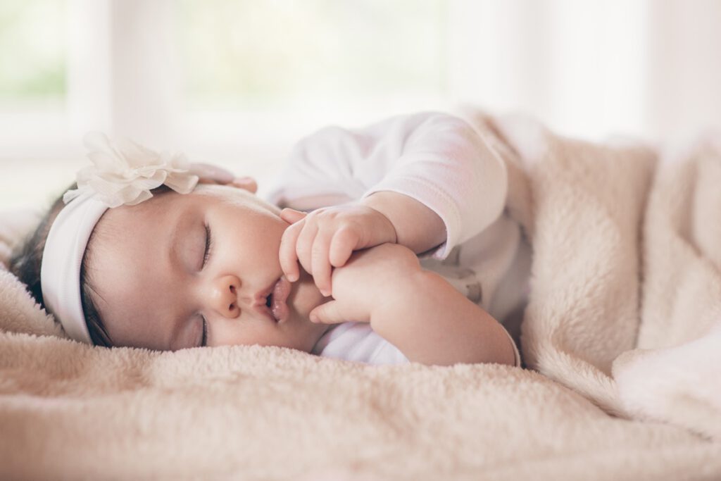 najpiękniejsze imiona żeńskie  - malutka śpiąca dziewczynka w opasce