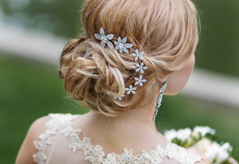 Delikatny kok z subtelną ozdobą jako przykład fryzury na wesele.