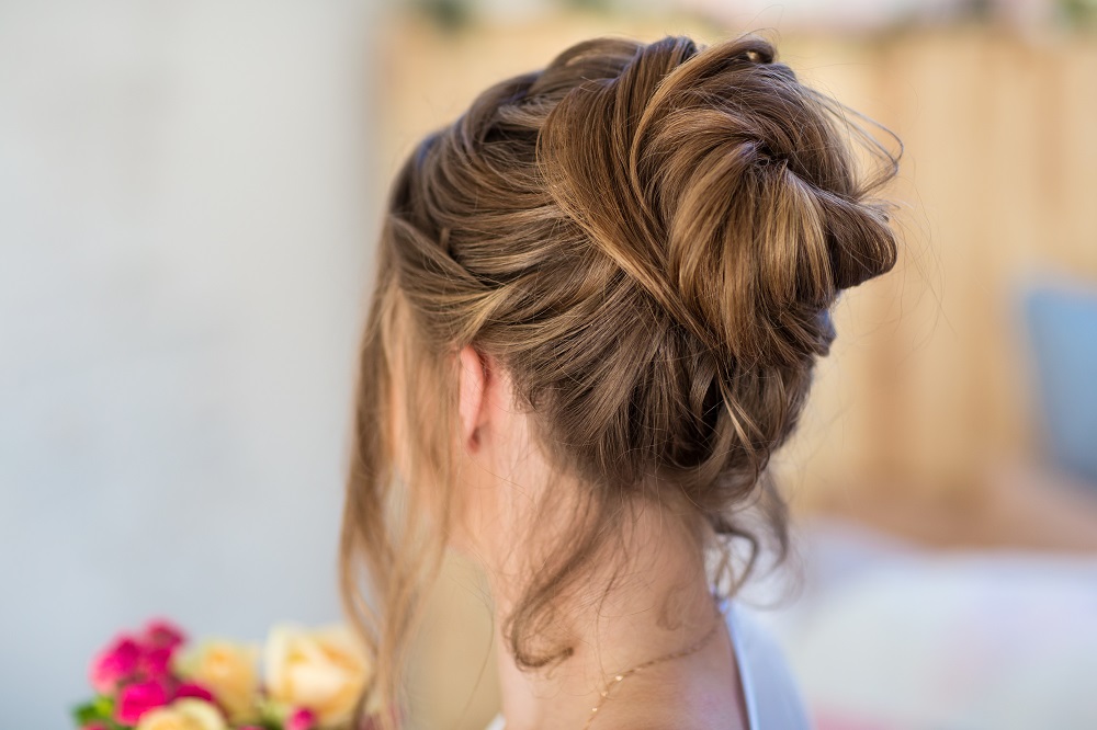 Delikatne upięcie na czubku głowy jako przykład fryzury na wesele.