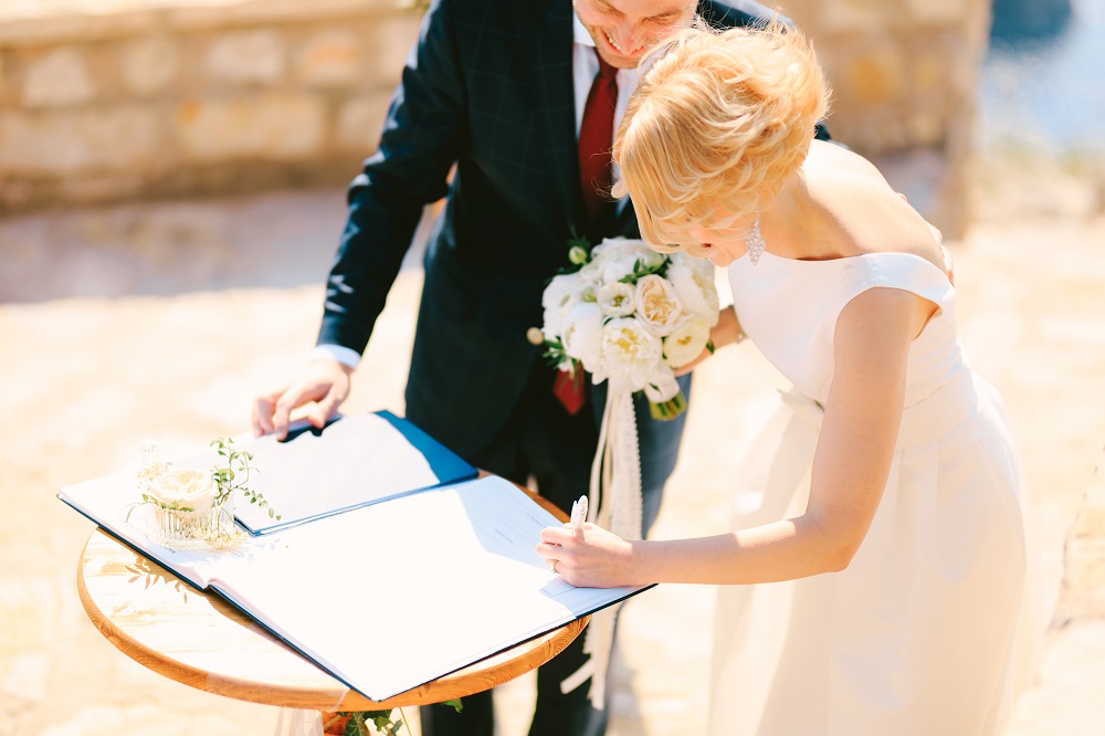 Ślub konkordatowy. Nowożeńcy podpisujący akt małżeństwa.