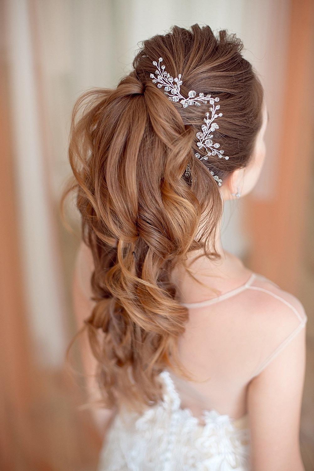 Piękny kok z długich włosów jako przykład fryzury na wesele.