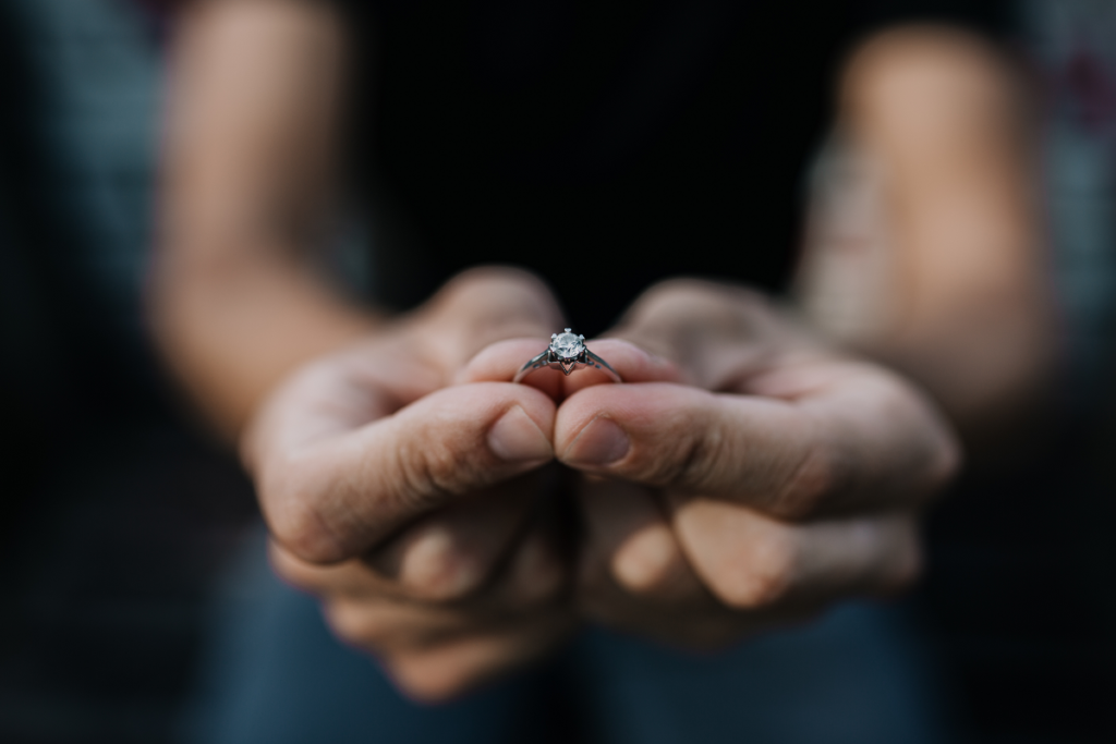 Oświadczyny - mężczyzna trzymający w ręku pierścionek zaręczynowy