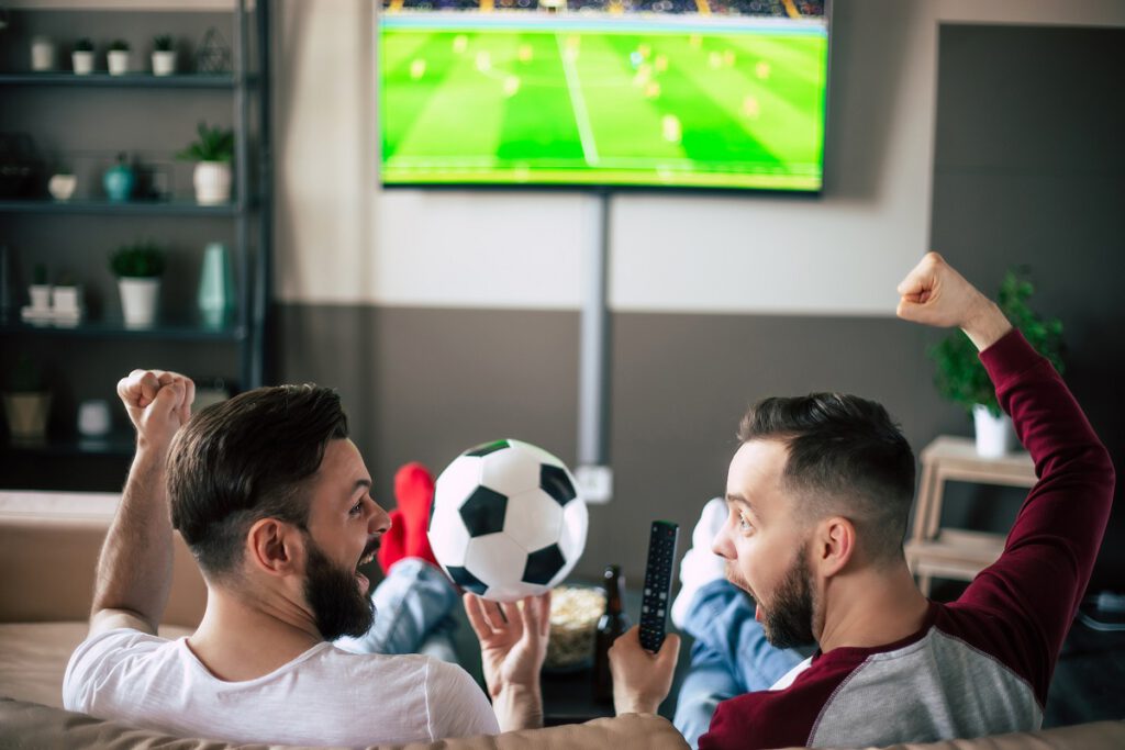 zabawy na kawalerski - mężczyźni oglądają wspólnie mecz piłki nożnej
