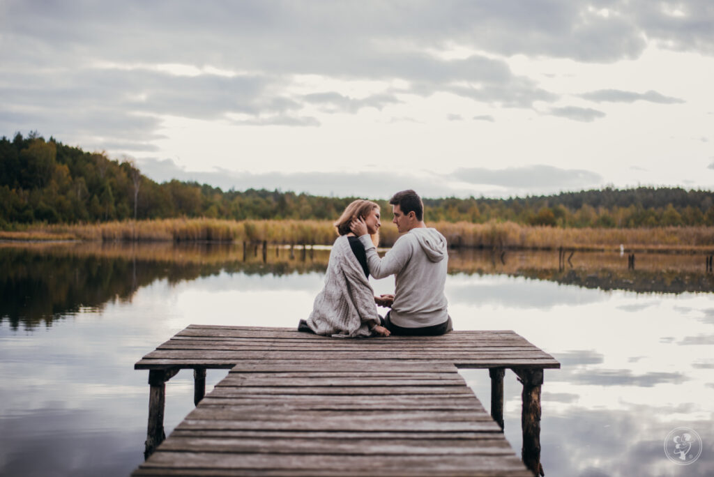 Życzenia na 1 rocznicę ślubu - para siedząca nad jeziorem
