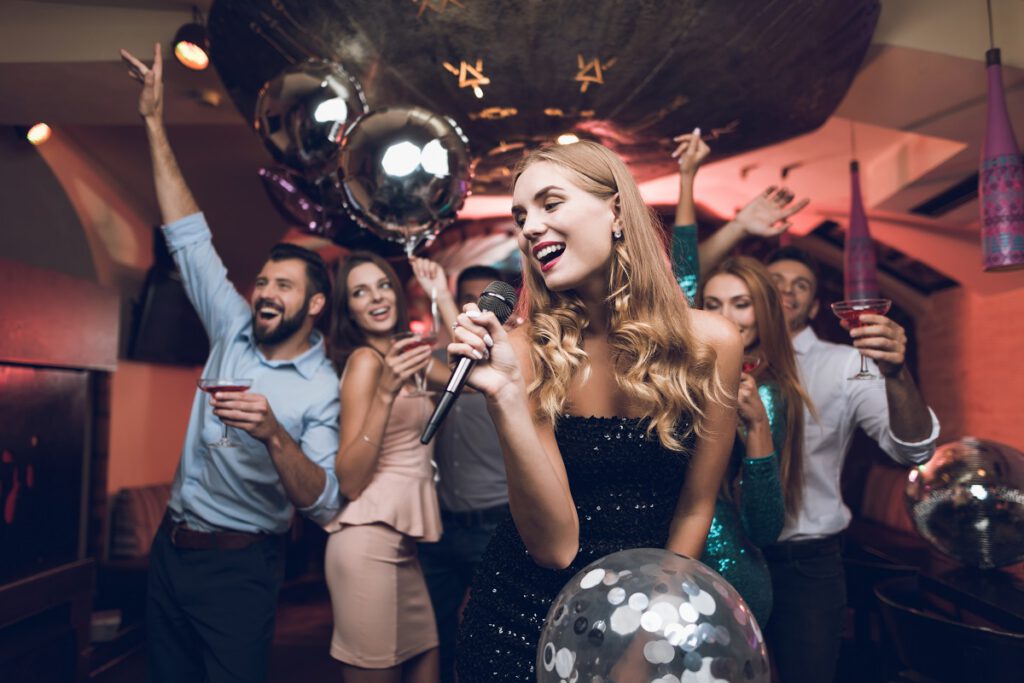 Atrakcje na wesele - dziewczyna śpiewająca do mikrofonu w trakcie karaoke na weselu