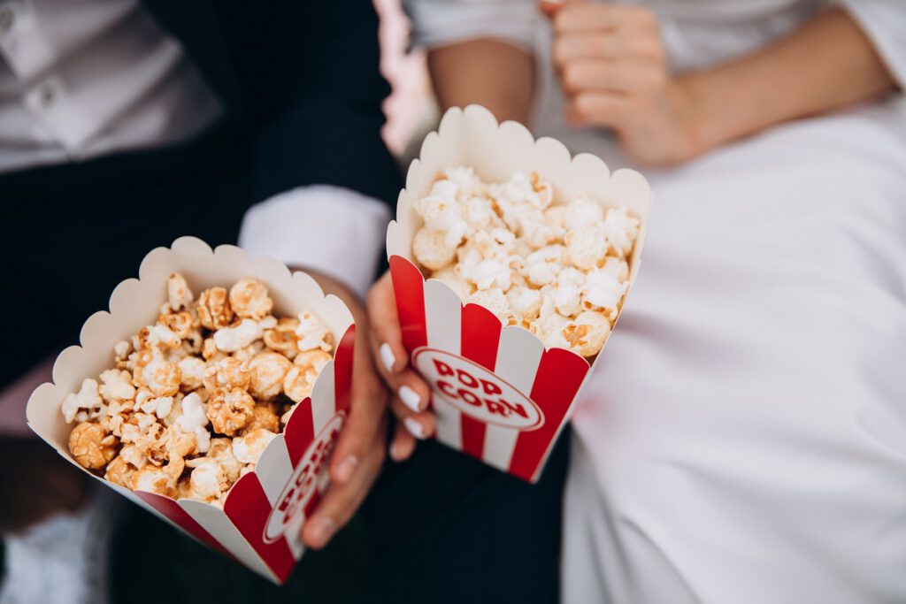 Atrakcje na wesele - popcorn trzymany w dłoniach przez parę młodą