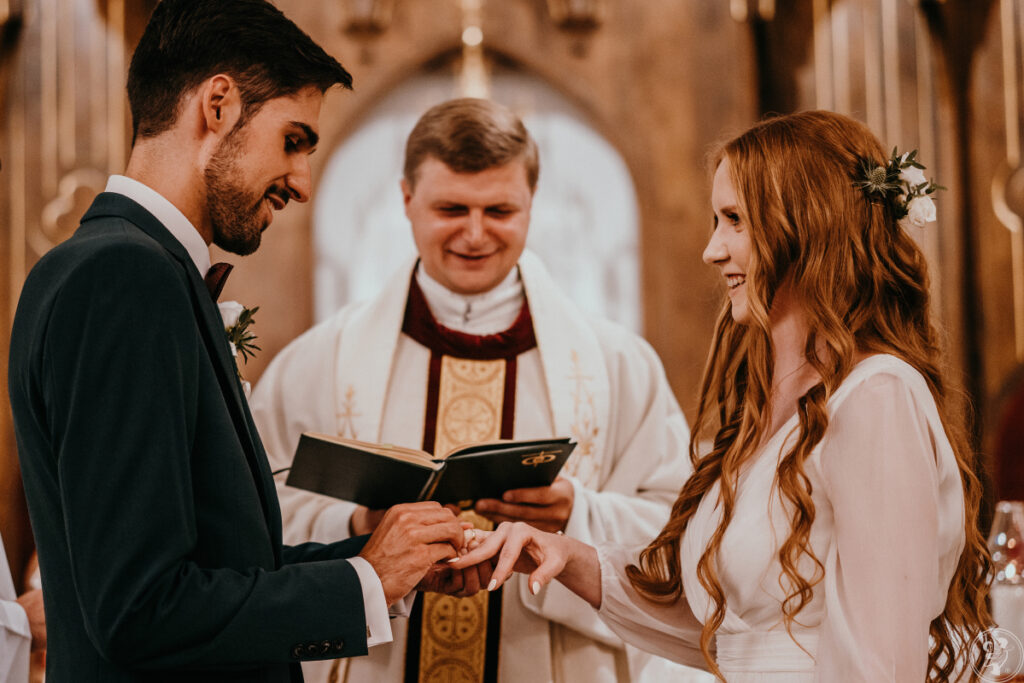 Przysięga małżeńska - para młoda zakłada obrączki ślubnej